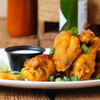 Smoked Chicken Wings  · Spicy. Tossed in buffalo sauce. Served with carrots, celery and your choice of blue cheese o...