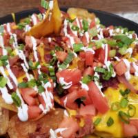 Spud Nachos · Home-made potato chips topped with queso cheese sauce, bacon bits, tomato, sour cream, green...