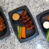 Wings · (buffalo, BBQ, lemon herb, or mesquite dry rub). Fried golden brown served with carrot and c...