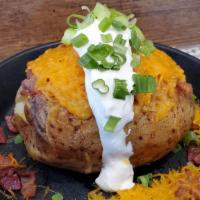 Loaded Skins · Freshly baked potato and lightly fried, topped with cheddar cheese, bacon, sour cream, green...