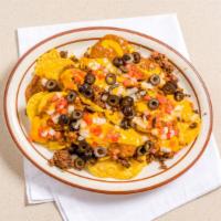 Nachos Supreme · With chili, cheese sauce, seasoned ground beef, black olives, tomatoes, onions, salsa, and s...
