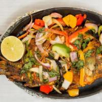 Tandoori Whole Fish · Marinated whole fish, Yak N Yeti Tandoori Masala, lemon juice, red-yellow onions, food color...