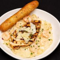 Chicken & Shrimp Alfredo · Fettuccine pasta tossed with alfredo sauce, red onions, garlic, and shrimp. Topped with blac...