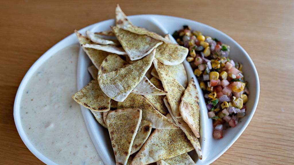 Pico Just In Queso · Toasted adobo pita chips accompanied by queso & pico.
Queso Dip: Hatch chili peppers, poblano peppers, jalapeno peppers, white cheddar 
Pico de gallo: Roasted corn, tomatoes, red onion, cilantro, fresh lime juice