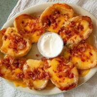 Potato Skins · Smothered with cheddar and jack cheese and topped with bacon.