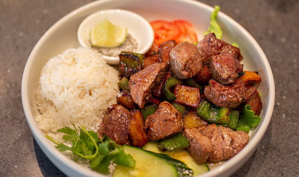 Shaken Beef · Vietnamese style filet mignon cubed steak. Sauteed with soy based marinade bell peppers, onions, scallions, garlic served over a bed of lettuce, and a side of steamed rice.