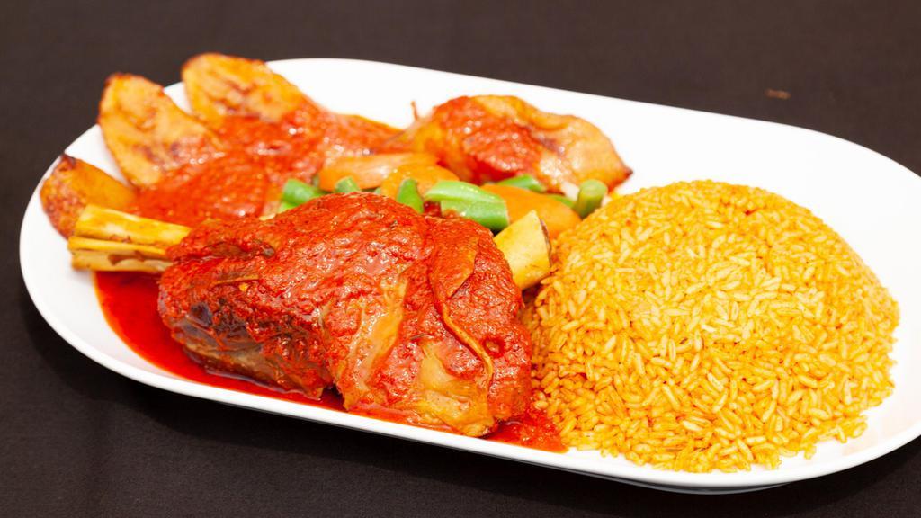 Braised Goat Shank Meal · Slowly braised goat shank, dipped in stew sauce and served over your choice of jollof, fried or stewed rice, plantain and sautéed mixed veggies
