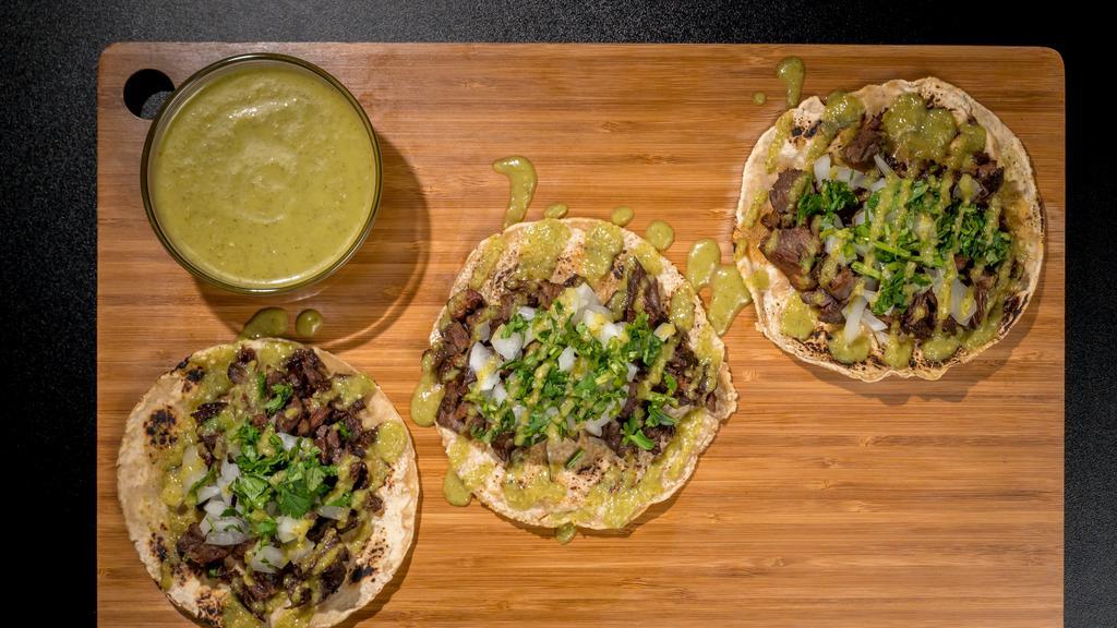De Asada Taco · Marinated skirt steak, topped with onions and cilantro.