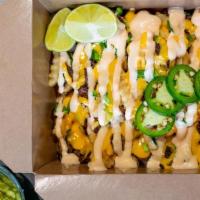 Asada Fries · Fries loaded with marinated skirt steak topped with cheddar cheese sauce, chipotle aioli, di...