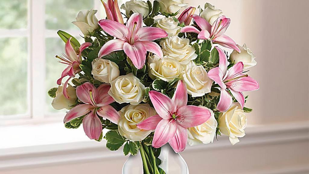 Always A Lady · A romantic gift like this one is always appreciated. An eye-catching display of roses and lilies is perfectly arranged in a feminine vase which makes a beautiful and lasting impression.
Elegant white roses and sweet pink Asiatic lilies are hand-arranged with greens. It's the perfect way to show you love her always and forever.