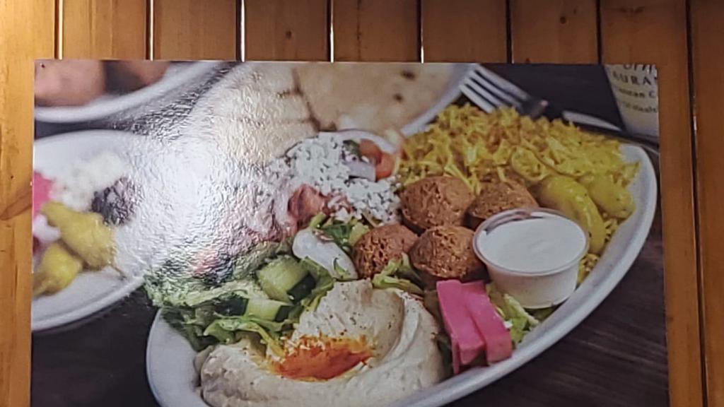 Vegetarian Plate · Three pieces of crispy falafel, rice, salad, hummus, tahini sauce, and pita bread.