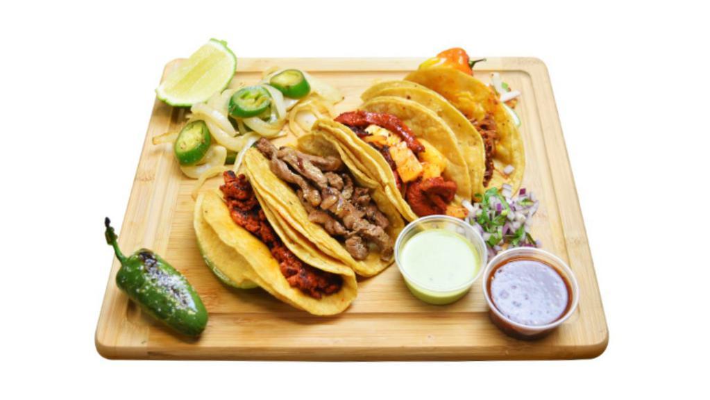 Tacos (3) · Al pastor, or carne asada, topped with cilantro, and onion, served with a side of grilled onions and jalapeño.