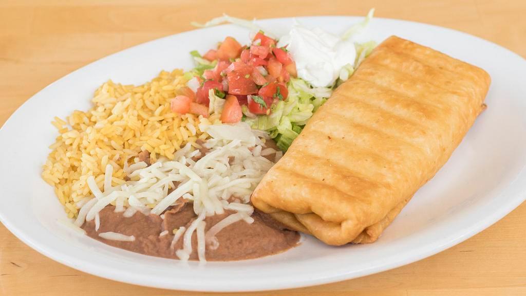 Chimichanga · 2 flour tortillas deep fried and filled with choice of beef tips or chicken, fried beans and rice topped with nacho cheese, garnished with guacamole salad.