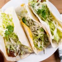 Fish Tacos · 3 soft flour tacos made with breaded mahi mahi topped with crema sauce and cilantro. Served ...