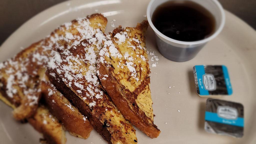 (2) Slices Of French Toast · 2 French toast sprinkled with powdered sugar and served with syrup.