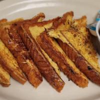 (3) Slices Of French Toast · 3 French toast sprinkled with powdered sugar and served with syrup.
