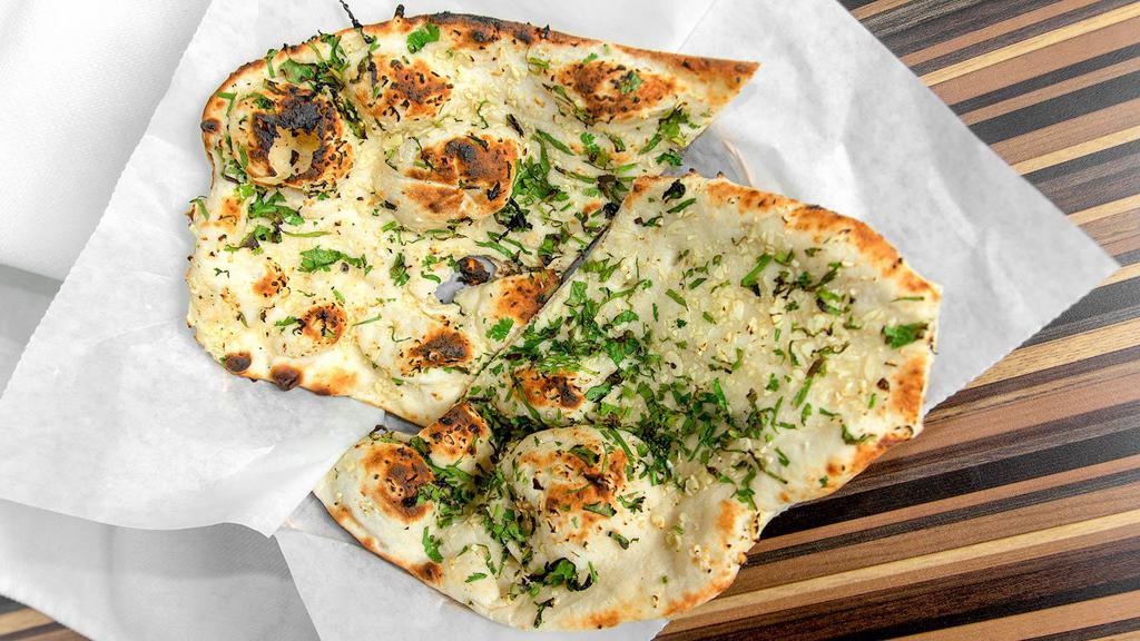 Garlic Naan · Bread topped with garlic and celetro.