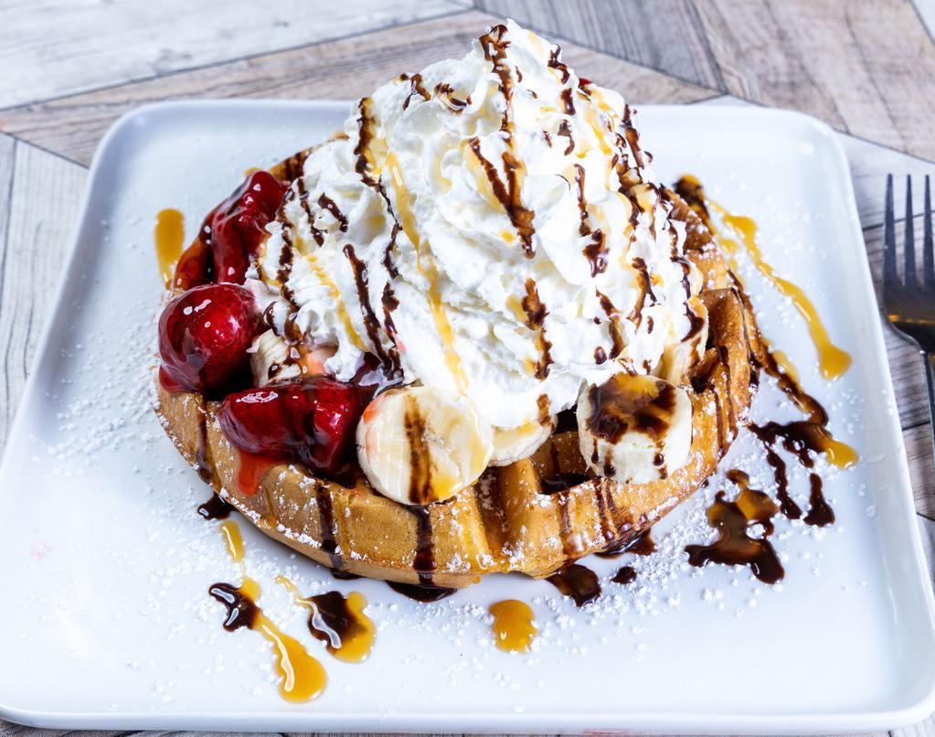 Waffle Sundae · Layered with Strawberries, Bananas & a Scoop of Vanilla Ice Cream. Finished with whipped Cream, Pecans and Drizzled with Chocolate Syrup and Caramel