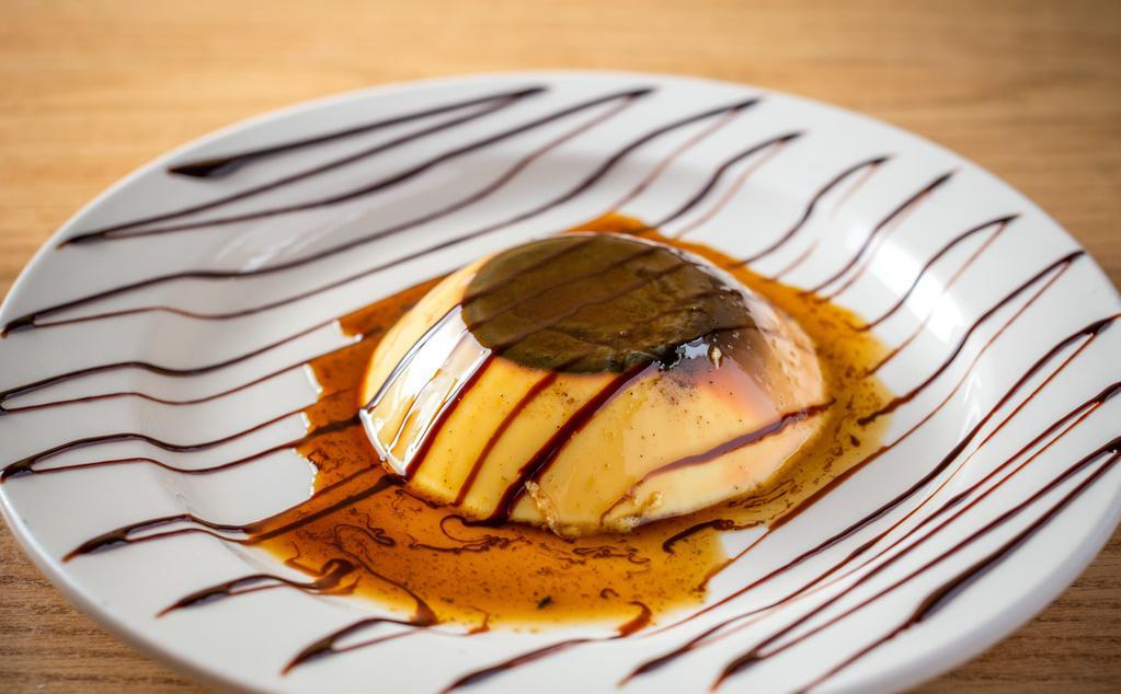 Flan · Traditional mexican dessert custard with a hint of caramel decorated with chocolate syrup and whipped cream.