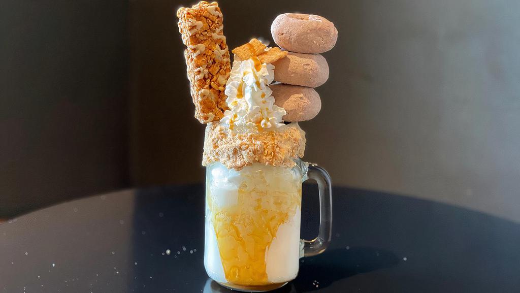Cinnamon Crunch Love · A to go cup filled with rich vanilla ice cream blended with Cinnamon Toast Crunch cereal. Topped with three 
cinnamon donuts, a cinnamon streusel cake, Cinnamon 
Toast Crunch cereal, whipped cream, and caramel drizzle.

Note: Images shown are how our amazing shakes look in store. They will taste just as amazing in your home, but may look a bit different. The shake will come deconstructed, and we will include all the items necessary to top your own!