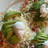 Avocado Tostadas  · Topped with beans, tomato, cheese, lettuce, and sour cream.