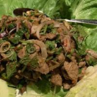 Fiery Beef Salad · Sliced grilled beef, lemongrass, mint, chili peppers, lime juice and cilantro. Served with g...