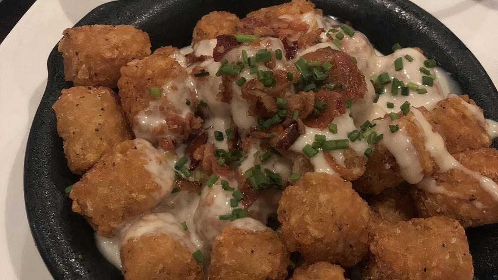 Loaded Tater Tots · Queso, smoked bacon bits, chives, cilantro sour cream served on the side. / Any additional sauces will only be included if paid for.