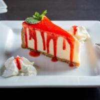 Cheesecake · Creamy cheesecake with graham cracker crust and strawberry sauce