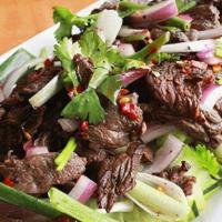 Yum Neau (Gf) · Sliced charbroiled tender beef in Thai hot & sour dressing with onions over fresh cucumbers ...
