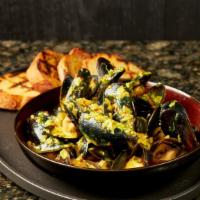 Prince Edward Island Mussels · White wine curry cream sauce, grilled polenta bread.