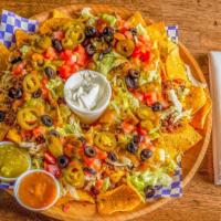 Loaded Nachos · Spicy. Ground beef, nacho cheese, lettuce, tomatoes, jalapeños, black olives, salsa and sour...