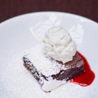 Brownie A La Mode · Warm brownie served with vanilla ice cream, chocolate sauce, and toasted pecans.