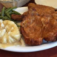 Breaded Pork Chops · Served with mashed potatoes gravy and vegetable.