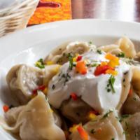 Siberian Pelmeni Dumplings · Beef and pork filled dumplings, buttered and served with sour cream and a side of vinegar.