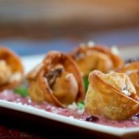 Fried Pelmeni · Beef and pork filled dumplings served with lingonberry sour cream, cilantro and freshly grat...