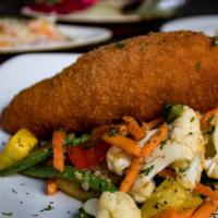 Chicken Kiev · Garlic dill butter stuffed chicken breast served with mashed potatoes and vegetables of the ...