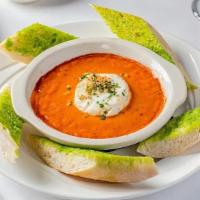 Queso De Cabra · Oven-baked goat cheese in tomato basil sauce, served with garlic bread