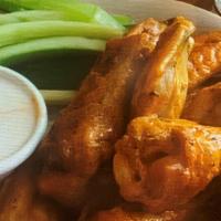 Baked Chicken Wings · Chicken wings baked until crispy, tossed in home-made buffalo or BBQ sauce and served with c...