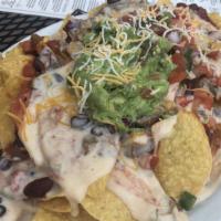 Tavern Nachos With Pulled Chicken & Black Beans · Tortilla chips topped with jalapeno, sour cream and house-made queso, guacamole and pico de ...