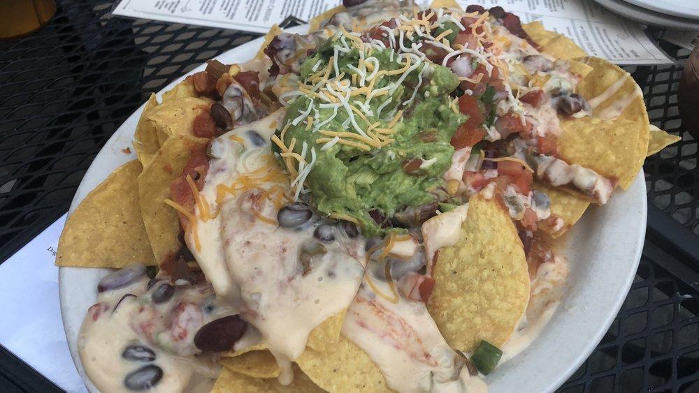 Tavern Nachos With Pulled Chicken & Black Beans · Tortilla chips topped with jalapeno, sour cream and house-made queso, guacamole and pico de gallo.
