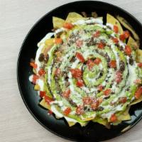 Nachos · Choice of meat, beans, tomato, sour cream, cheese and guacamole.