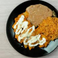 Chilaquiles · Topped with sour cream & cheese with side of rice & beans.