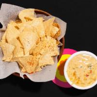 Chips And Queso · Tortilla chips with cheesy queso sauce.