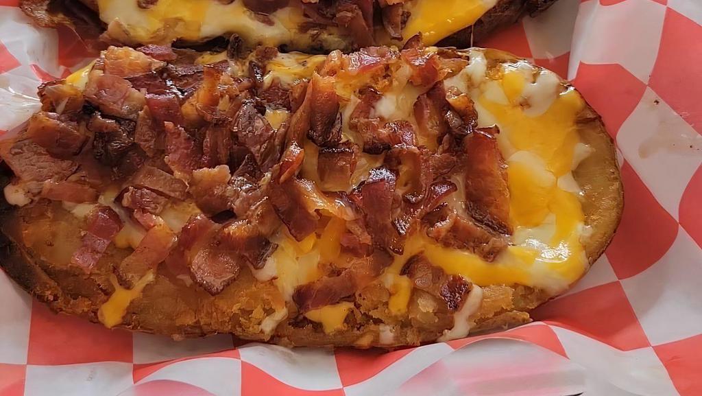 Potato Skins · Deep Fried Potato Skins topped w/ melted cheese, freshly chopped bacon & grilled onions & side of sour cream.