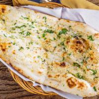 Garlic Cilantro Naan · Flat bread with toppings of garlic and cilantro cooked in north Indian style clay oven.