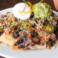 Nachos · Crisp corn tortillas topped with beans, tomato sauce & cheese served with guacamole & sour c...