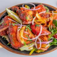 Tandoori Chicken · Marinated chicken leg and thigh cooked in the tandoor with spices.
