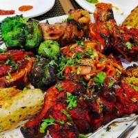 Tandoori Mixed Grill · Chicken seek kabob, chicken malai kabob, chicken tikka, and shrimp tikka. in a big platter.