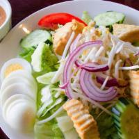 Thai Peanut Salad · Lettuce, cucumber, tomatoes, red onions, bean sprouts, fried tofu, and hard boiled eggs, ser...
