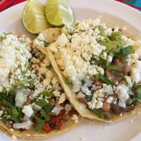 Tacos Ranchero · Double corn tortilla taco filled with your choice of meats and topped with whole beans, cila...